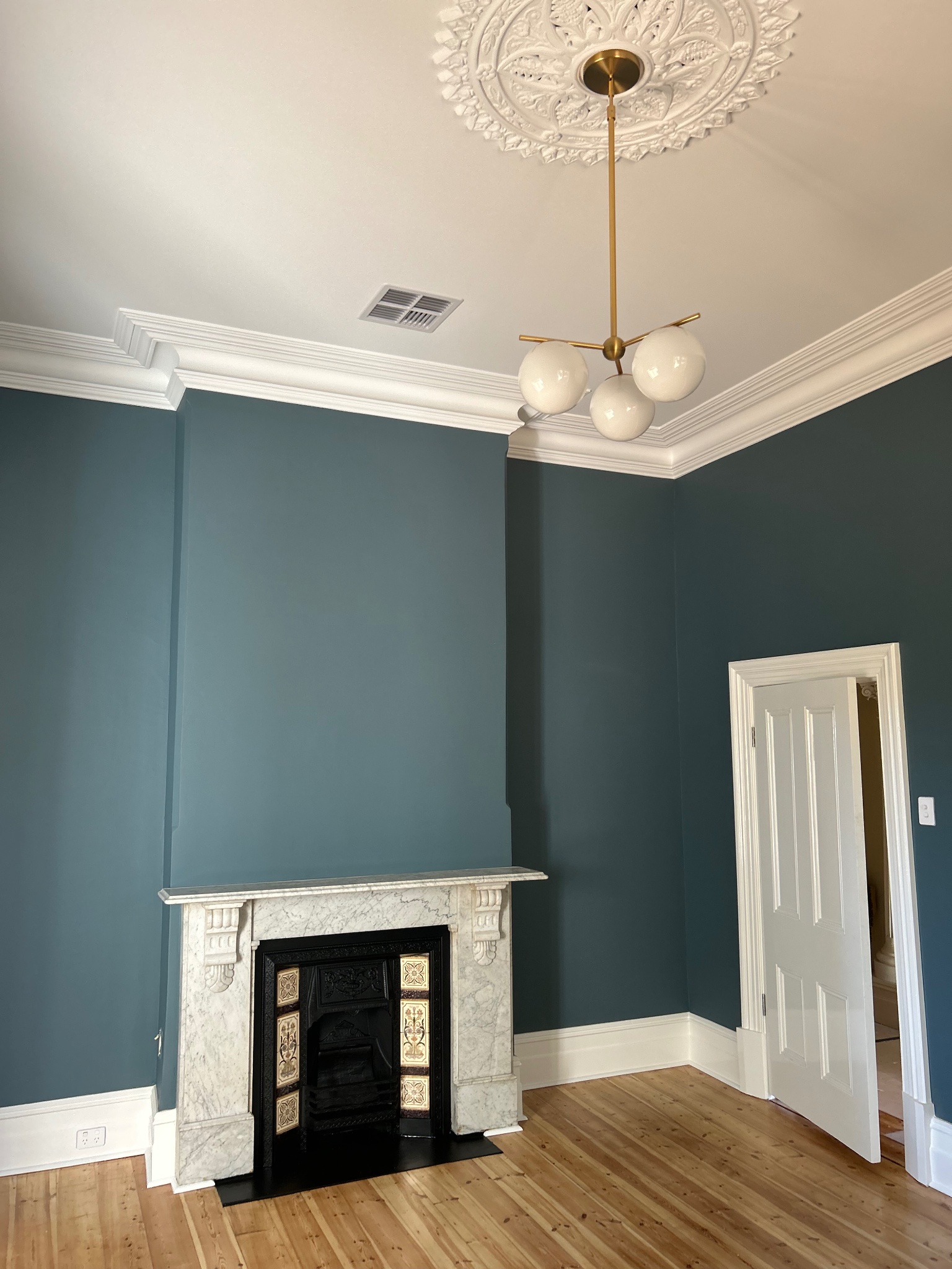 Restored heritage room with ornate ceiling rose, decorative cornice and marble fireplace